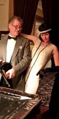 Two people dressed as a 1920s gangsters playing A Speakeasy Murder