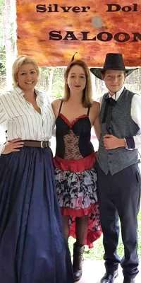 Three people dressed in wild west outfits for the Way out West murder mystery game