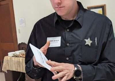 A person in a sheriff costume playing the Way out West murder mystery game