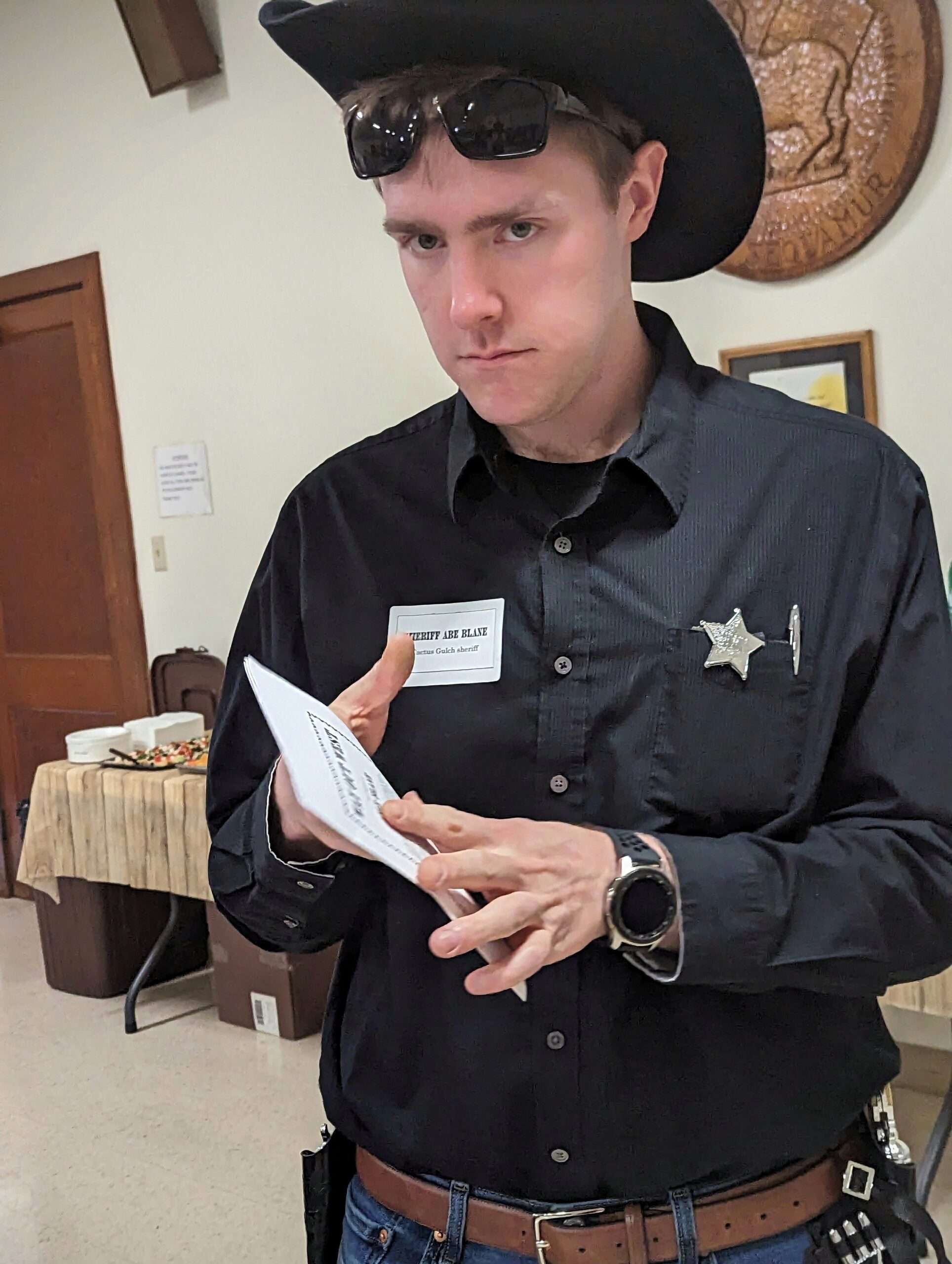 A person in a sheriff costume playing the Way out West murder mystery game